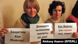 Активистки держат плакаты против строительства курорта "Кокжайляу". Алматы, 11 января 2013 года.