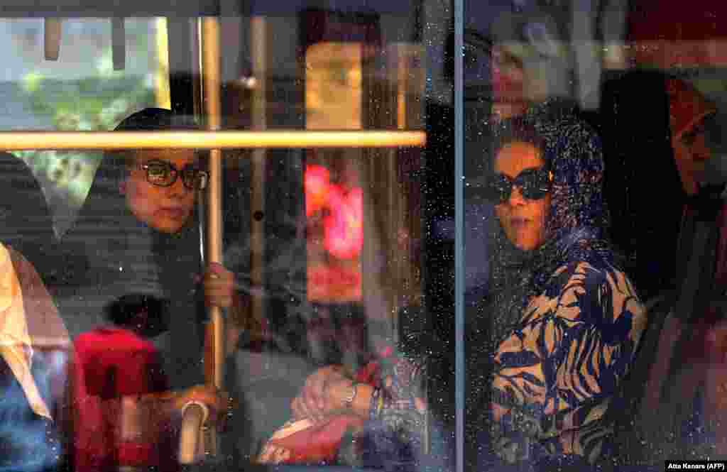 Iranian women sit on a bus in Tehran. (AFP/Atta Kenare)