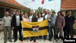 Вит Једличка (во средината) позира со знамето на Либерланд и идни граѓани во српско село во 2015 година.