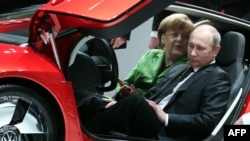 Angela Merkel şi Vladimir Putin într-un Volkswagen XL 1 Hybrid, la Târgul industrial de la Hanovra, 8 aprilie 2013