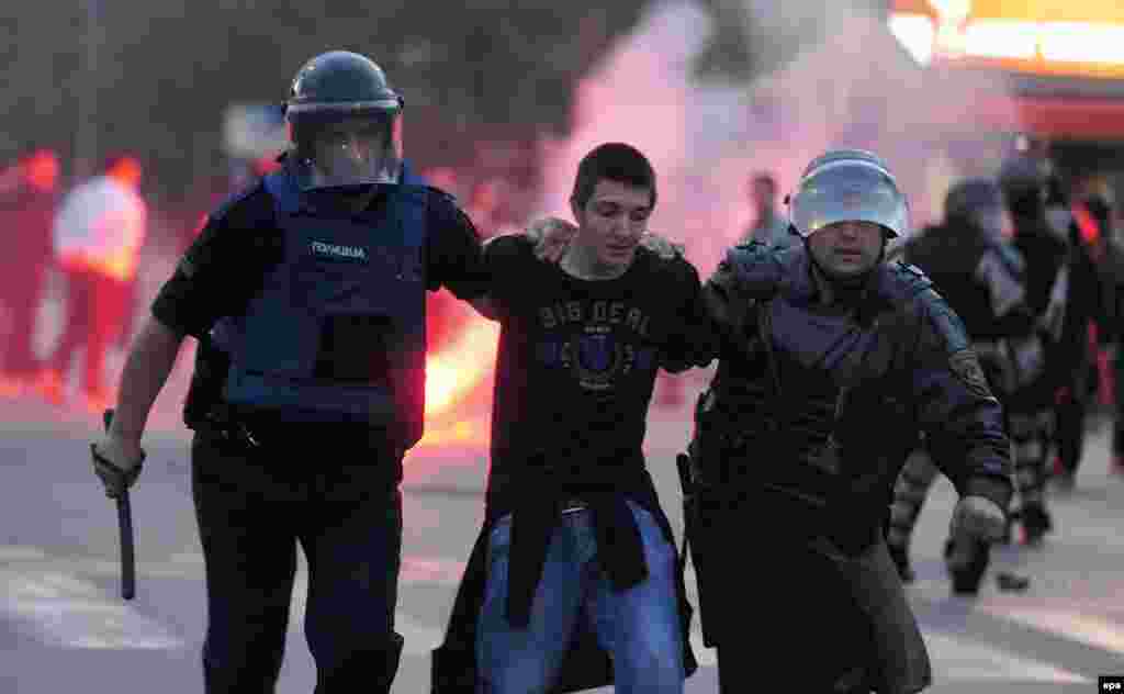 Riot police arrest a protester in Skopje on May 20.