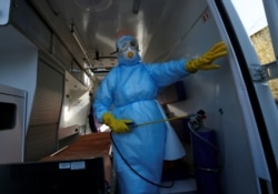 A medical worker sprays disinfectant inside an ambulance at the Vishnevsky hospital in the separatist-controlled city of Donetsk on March 17.