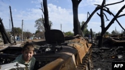 Хлопчик в знищеній бронемашині в місті Лутугине, 20 км від Луганська. Вересень 2014 року