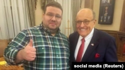 Andriy Telizhenko (left) and Rudy Giuliani pose for a picture during a meeting in Kyiv.