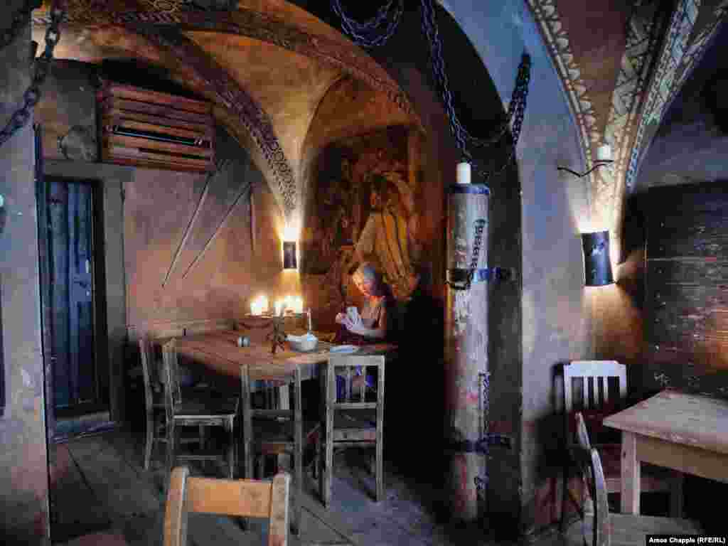 Женщина делает селфи в ресторане со средневековой тематикой. Ресторанам и барам также позволили открыться 25 мая
