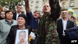 A woman holds a portrait of her dead son, who served in a volunteer battalion, during a rally in front of Ukrainian President Petro Poroshenko's office in Kyiv on August 27.