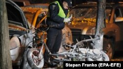 A policeman examines the crime scene after an explosion in which Ihor Mosiychuk was wounded and his bodyguard killed in central Kyiv on October 25.