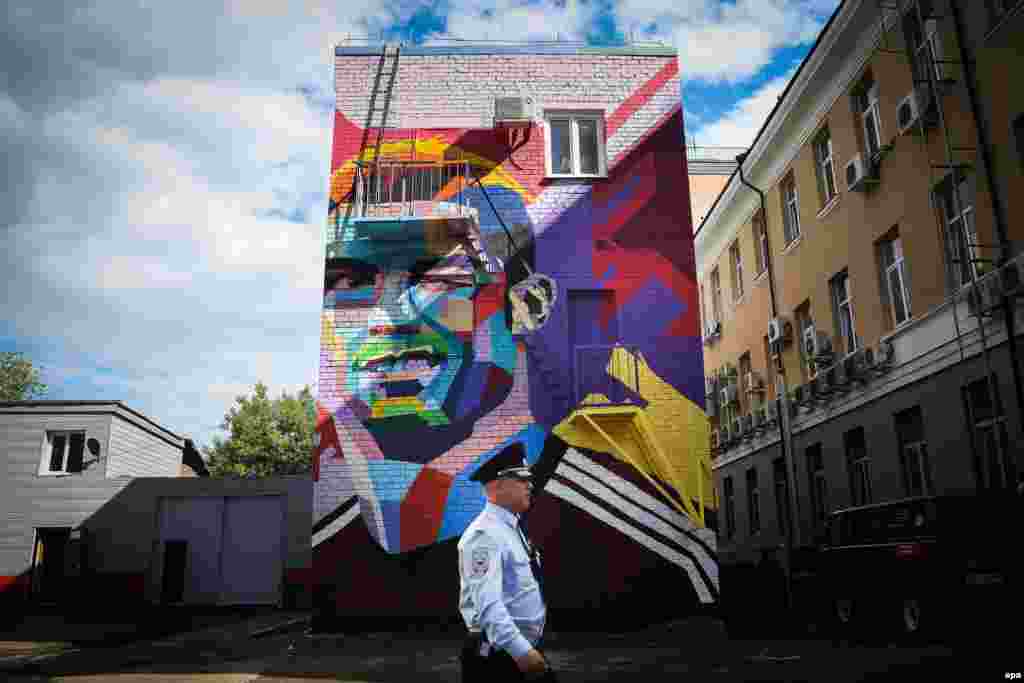 A security guard passes by graffiti featuring Portuguese player Cristiano Ronaldo in central Kazan, Russia, ahead of the FIFA Confederations Cup on June 15. (epa/Mario Cruz)
