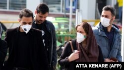 Иранцы надевают защитные маски на улицах Тегерана. 22 февраля 2020 год.