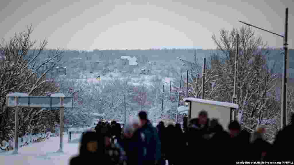 A last Ukrainian flag marks the edge of territory safe for RFE/RL&#39;s correspondents. In the empty houses on the hill, snipers often set up after the &quot;border&quot; closes at 5 p.m. A Ukrainian soldier was wounded by a sniper firing from this hill around one week before RFE/RL visited. &nbsp;