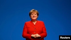 German Chancellor Angela Merkel reacts after she was reelected as chairwoman at the CDU party convention in Essen on December 6.