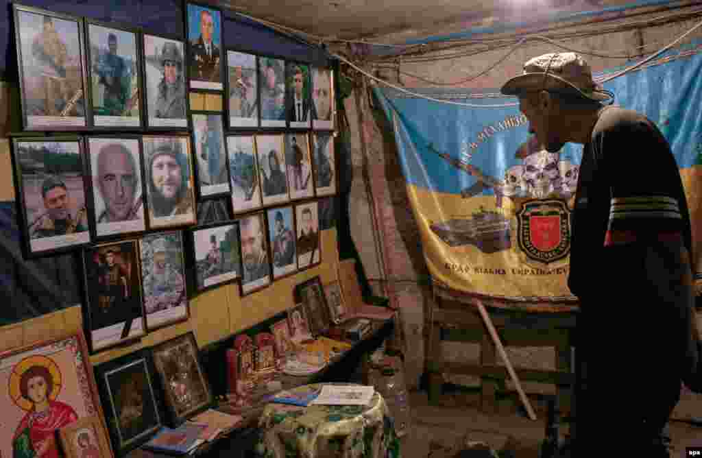 A Ukrainian serviceman looks at portraits of lost friends in a shelter at their position on the front lines near Avdiyivka. (epa/Valeri Kvit)