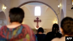 Iraqi Christians fleeing the violence in the towns of Qaraqush and Bartala, both east of the city of Mosul in the northern province of Nineveh, pray at the St. George Church in the Kurdish autonomous region's capital, Irbil.