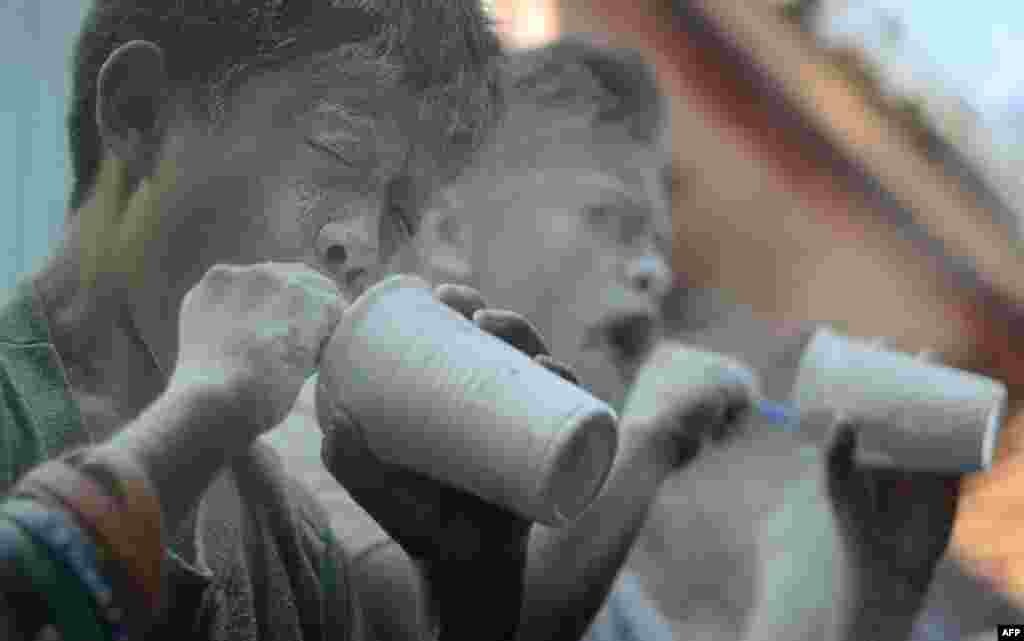 Children blow through straws in a race to empty cups full of flour during the annual Feast Day of St. Rita of Cascia in Manila. (AFP/Noel Celis)