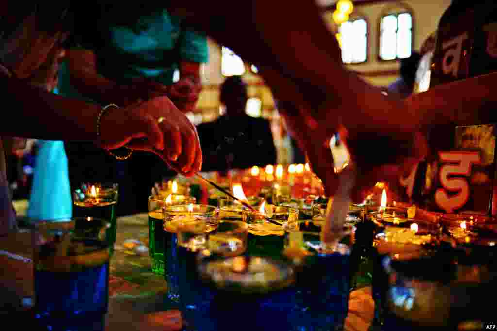Women light candles in the Kenyan capital, Nairobi,on September 28 at the beginning of a 24-hour prayer vigil for victims of the Westgate mall massacre that left dozens dead. (AFP/ Carl de Souza)