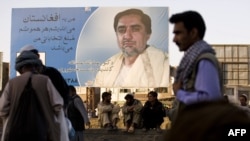 Presidential candidate Abdullah Abdullah watches over Afghans from a campaign billboard in Kabul in early August.
