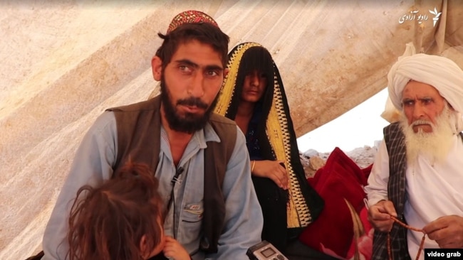 Mohamed Hanif u krilu drži kćerkicu koju je prodao da bi omogućio porodici da preživi.