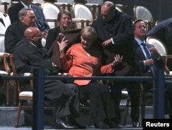 Putin pune un șal pe umerii Angelei Merkel care stă alături de David Cameron în timpul întâlnirii G20 din St. Petersburg, pe 6 septembrie, 2013