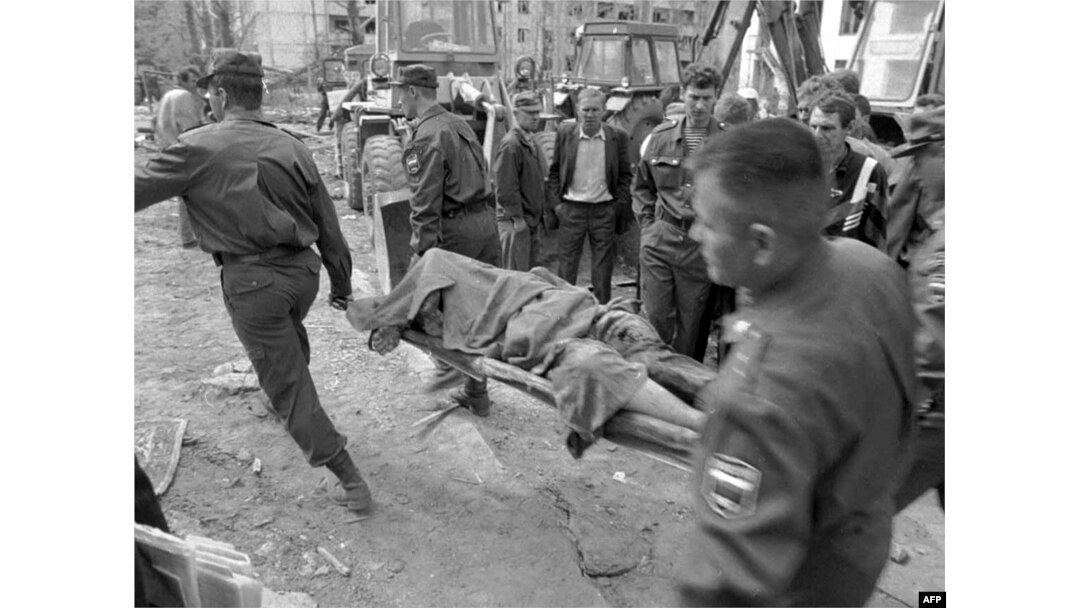 Ekipet e shpëtimit shihen duke bartur trupin e një viktime pasi sulmi me makinë-bombë ka rezultuar me shkatërrim të një ndërtese në Volgodonsk. Fotografi e vitit 1999.