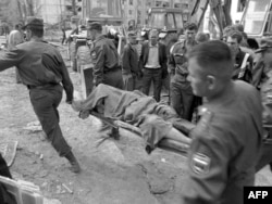 Спасатели несут тело одной из жертв взрыва в Волгодонске 16 сентября 1999 года