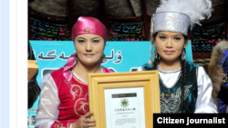 Девушки показывают сертификат о внесении в Книгу рекордов Гиннесса чая из Алтая. Фото с официального веб-сайта администрации города Алтай в Китае.
