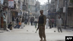 A soldier keeps watch during a curfew in Rawalpindi on November 16. The curfew was imposed after deadly clashes erupted there last week. 