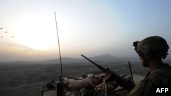 A U.S. soldier stands guard on a watch tower overlooking villages at Combat Outpost Sabari in the Khost Province in June