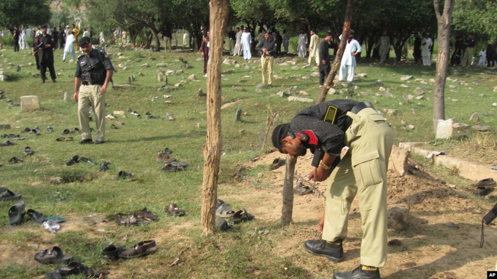 A police officers collects evidence at the site of a suicide bombing in Lower Dir in September 2011. (file photo)