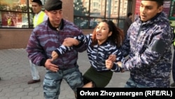 Сотрудники спецподразделения полиции задерживают девушку на месте, которое запрещенное в Казахстане движение указало как площадку проведения протеста. Нур-Султан, 21 сентября 2019 года.