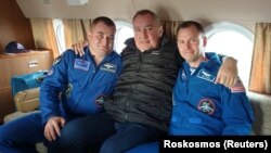 Roskosmos chief Dmitry Rogozin (center) poses with Russian cosmonaut Aleksei Ovchinin (left) and U.S. astronaut Nick Hague after their emergency landing.