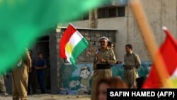 Un kurd Peshmerga membru al Partidului Democratic Kurdistan din Iran (KDP-Iran), la o adunare menită să îndemne oameni săp voteze la referendum, Bahirka, 25 septembrie