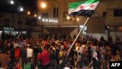 A protester waving a pre-Baath Syrian flag during an antiregime demonstration in Dael in the southern Daraa Province on April 12.