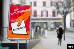 "В эти выходные – голосование", – напоминает избирателям плакат накануне референдума в одном из швейцарских городов