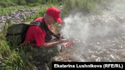 Дмитрий Левашов замеряет уровень загрязнения на свалке