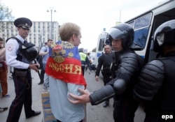 Russian police officers detain a participant at an opposition rally on Tverskaya Street in central Moscow on June 12.