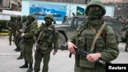 Armed servicemen stand near Russian Army vehicles outside a Ukrainian border-guard post in the Crimean town of Balaclava.