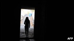 Жінка стоїть на виході зі сховища, Луганська область