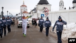 A torchbearer carries an Olympic torch in the Volga River town of Sviyazhsk, some 690 kilometers east of Moscow, on December 27.