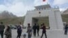 FILE: Tourists gather near the China-Pakistan border crossing at the Khunjerab Pass, on the upgraded Karakoram Highway. 
