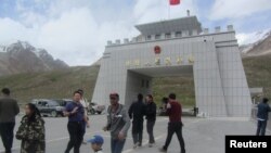 FILE: Tourists gather near the China-Pakistan border crossing at the Khunjerab Pass, on the upgraded Karakoram Highway. 