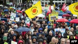 People hold flags and placards on November 29 during a environmental march in Amsterdam on the eve of the official opening of a UN climate summit in Paris. 