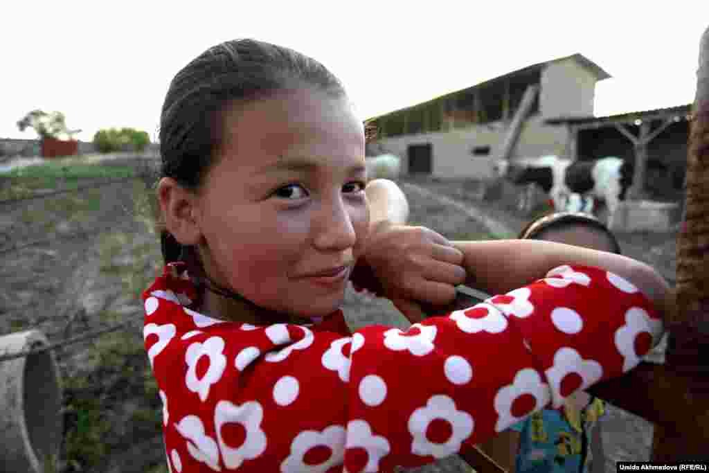 Дети в селе помогают родителям по домашнему хозяйству. Эта девочка собирается привязать вернувшуюся с пастбища буренку.