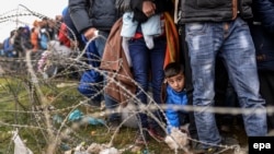 A boy looks on as he waits in line for permission to cross the border between Greece and Macedonia after Macedonia started granting passage only to refugees from Syria, Iraq, and Afghanistan last month.