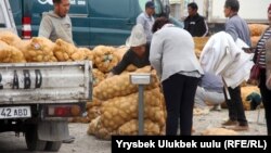 Женщина покупает картофель на рынке «Сары-Озон» в Бишкеке. 11 октября 2018 года.
