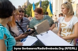 Татьяна Бондарь (в центре) собирает подписи под резолюцией митинга