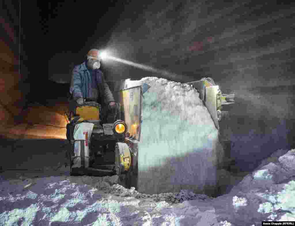 A worker pours freshly ground salt into a heap. From here it will be transported to the surface.