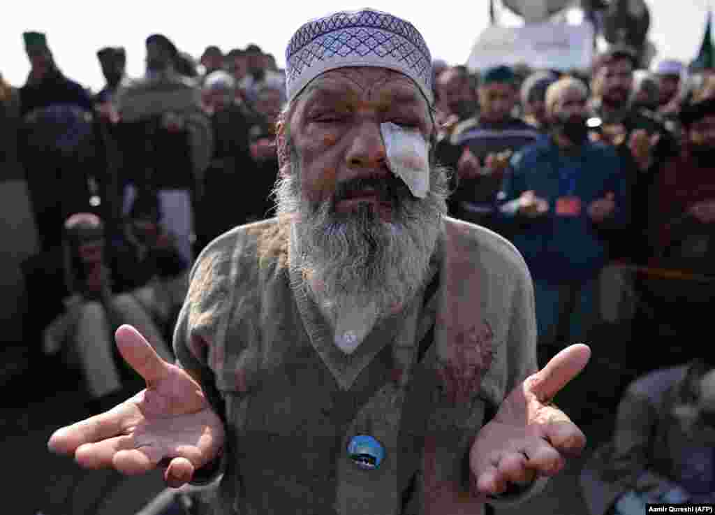 An injured elderly Pakistani protester of the Tehreek-e Labaik Yah Rasool Allah Pakistan religious group prays along with others after their leader announced the end of a sit-in protest on a blocked flyover bridge in Islamabad on November 27. (Reuters/Vasily Fedosenko)