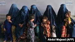 Afghan women wait during the visit of UN High Commissioner for Refugees Filippo Grandi at the Azakhel Voluntary Repatriation Center in Khyber Pakhtunkhwa Province on September 9.