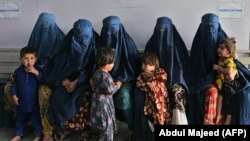 Afghan women wait during the visit of UN High Commissioner for Refugees Filippo Grandi at the Azakhel Voluntary Repatriation Center in Khyber Pakhtunkhwa Province on September 9.