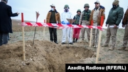 Workers dealing with unexploded ordnance inspect a blast site in Nagorno-Karabakh. (file photo)
